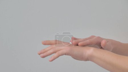 Photo for Close-up of woman's hands applying moisturizing cream on the skin isolated on a white background. Skin care concept. - Royalty Free Image