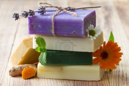 Stack of natural soaps with medicinal plants, flowers and turmeric