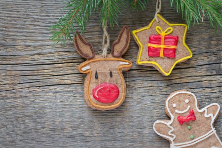Téléchargez les photos : Biscuits faits maison de Noël suspendus sur fond en bois - en image libre de droit