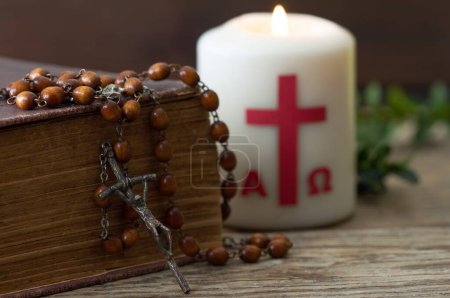Téléchargez les photos : Croix en bois avec bible, chapelet et bougie pascale, concept religieux de Pâques - en image libre de droit