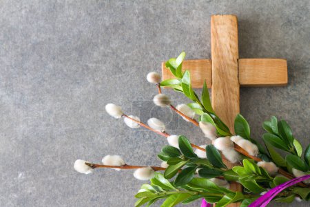 Wooden cross and easter palm tree made of catkins and boxwood, palm sunday concept 