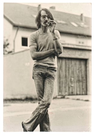 Téléchargez les photos : ALLEMAGNE - BERLIN, 26 novembre 2023 : Photo vintage d'un homme fumeur portant des vêtements hippies typiques des années 70. Image rétro avec grain de film original et rayures - en image libre de droit