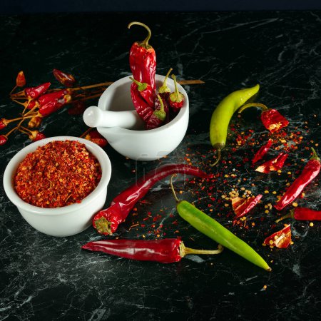 Photo for Chili pepper fruit and pepper powder on a black background. - Royalty Free Image