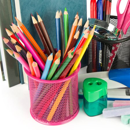 Ensemble de crayons de couleur et fournitures scolaires isolés sur fond blanc.