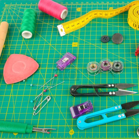 Photo for A set of sewing accessories laid out on a patchwork mat. - Royalty Free Image