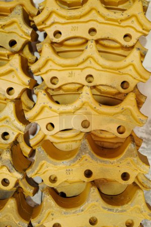 Téléchargez les photos : Several stacks of spare parts for yellow iron cogwheels being sections of cog mechanism of huge industrial or construction machines - en image libre de droit
