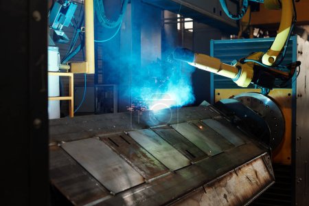 Téléchargez les photos : Process of arc welding produced by huge robotic industrial machine in large workshop of contemporary factory or plant - en image libre de droit