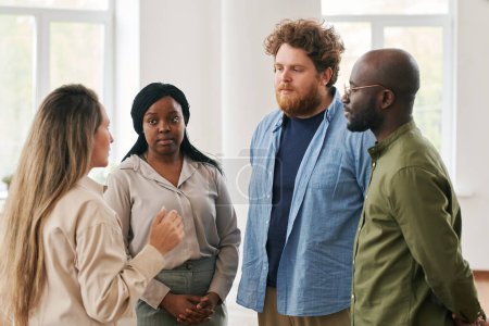 Téléchargez les photos : Groupe de jeunes personnes interraciales discutant de leurs problèmes et se donnant des conseils tout en assistant à un cours d'aide psychologique - en image libre de droit