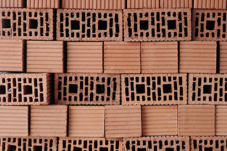 Téléchargez les photos : Empilement de briques d'argile solide rouge formées par plusieurs couches préparées pour le travail de construction tout en faisant fond ou papier peint - en image libre de droit