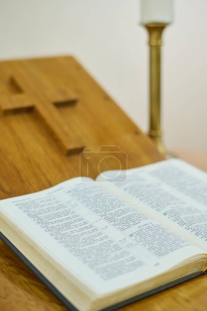 Foto de Parte del púlpito de madera con cruz cortada y Biblia Santa abierta con versículos del Nuevo o Antiguo Testamento preparados para el sermón por el predicador - Imagen libre de derechos