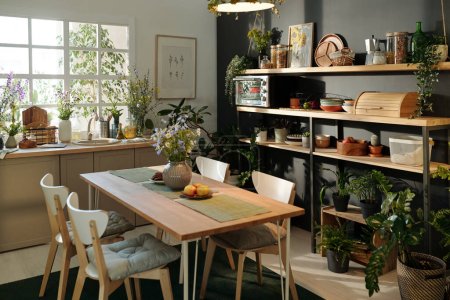 Teil der geräumigen, gemütlichen Küche mit nachhaltigem Tisch, Geschirr und Zimmerpflanzen, die eine Atmosphäre des Aufladens und der Entspannung schaffen