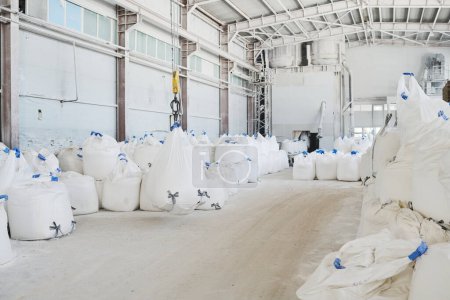 Foto de Amplia planta industrial o taller de manufactura moderna con montones de sacos blancos enormes y pesados con materias primas - Imagen libre de derechos
