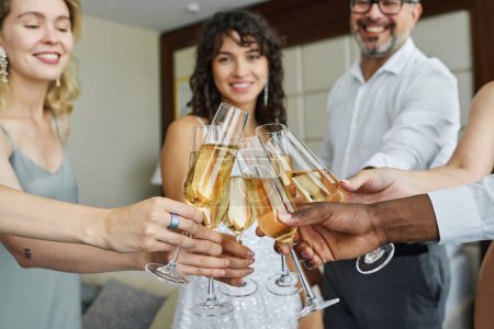 Téléchargez les photos : Mains d'invités interculturels cliquetis avec des flûtes de champagne devant la caméra tout en se tenant en cercle à la fête de mariage - en image libre de droit