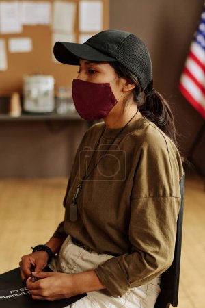 Foto de Joven mujer hispana estresada en máscara protectora describiendo sus problemas psicológicos causados por el síndrome postraumático - Imagen libre de derechos
