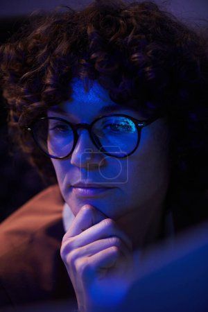 Téléchargez les photos : Jeune femme d'affaires avec expression faciale coûteuse assise devant l'ordinateur et regardant l'écran tout en se concentrant sur le travail - en image libre de droit