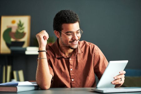 Junge lächelnde männliche Studenten des Online-Studiengangs schauen auf den Tablet-Bildschirm, während sie am Schreibtisch sitzen und sich die Videostunde anschauen