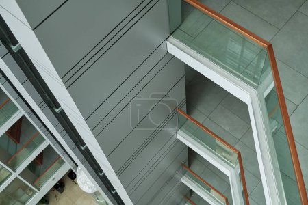 Téléchargez les photos : Vue ci-dessus d'une partie de l'intérieur du bâtiment moderne avec des balustrades et des clôtures en verre transparent décorant chaque étage - en image libre de droit