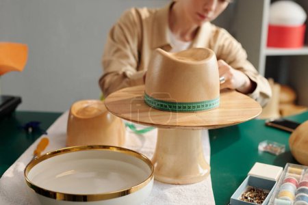 Photo for Close-up of wooden workpiece in form of hat against young craftswoman measuring circumference while creating new items for sale - Royalty Free Image