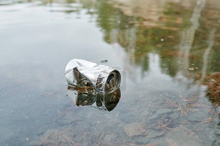 Téléchargez les photos : Canette en aluminium dans l'eau, concept de lac pollué - en image libre de droit