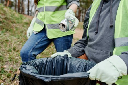 Téléchargez les photos : Des bénévoles mettent les ordures qu'ils ont trouvées dans la forêt dans un grand sac en plastique - en image libre de droit