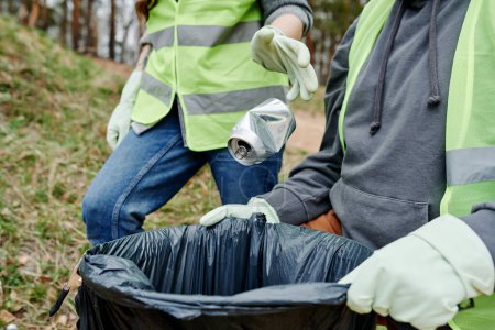 Téléchargez les photos : Jeter bénévolement peut dans un grand sac en plastique pour les ordures - en image libre de droit