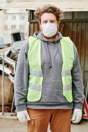 Photo for Portrait of serious scrapyard worker in medial mask looking at camera - Royalty Free Image