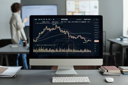Computerbildschirm mit Finanzdiagramm und Grafik, erstellt von Analyst oder Händler gegen jungen Ökonomen, der am Whiteboard steht