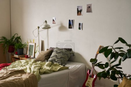 Foto de Imagen horizontal del dormitorio adolescente con cama cómoda y fotos en la pared - Imagen libre de derechos