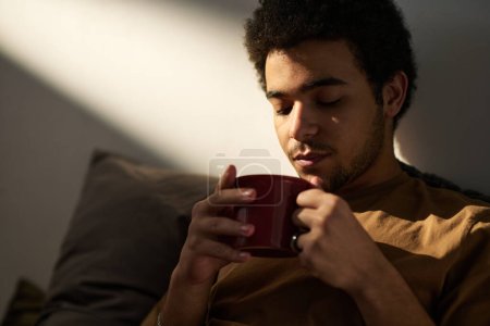 Photo for Young man in melancholy enjoying hot coffee and thinking about his life moments - Royalty Free Image