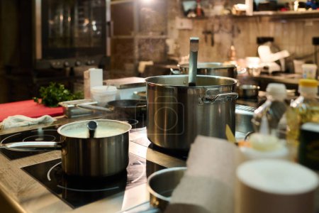 Téléchargez les photos : Cuisinière électrique avec deux casseroles métalliques contenant du bouillon bouillant ou un mélange fumant d'ingrédients pendant le processus de cuisson - en image libre de droit