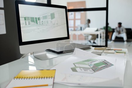 Photo for Computer monitor with architectural sketches on screen standing on workplace of building designer with blueprint and open notebook - Royalty Free Image