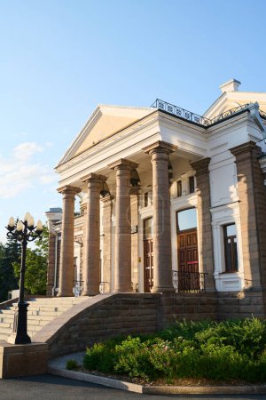 Foto de Fachada de monumento arquitectónico de estilo clásico con columnas, farolas y escalera de pie en entorno urbano - Imagen libre de derechos