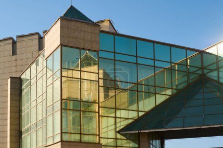 Téléchargez les photos : Partie supérieure du coin du bâtiment moderne en verre avec une variété d'éléments élégants et géométriques debout dans le centre-ville - en image libre de droit