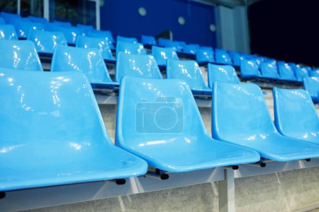 Téléchargez les photos : Pas de personnes sur des chaises bleues en plastique de tribune vide au stade moderne spacieux pour les fans de divers matchs sportifs, compétitions et jeux - en image libre de droit
