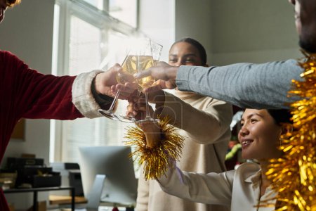 Photo for Group of happy young intercultural managers toasting with sparkling champagne for good luck in business while enjoying, office party - Royalty Free Image