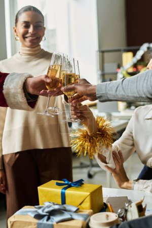 Photo for Happy young intercultural white collar workers with flutes of champagne toasting for new business during Christmas party in office - Royalty Free Image