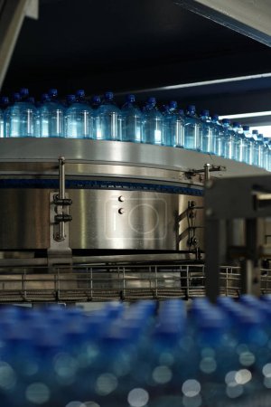Photo for Part of production line of filtered bottled mineral water moving on conveyor belt inside large factory of packaged drinks - Royalty Free Image
