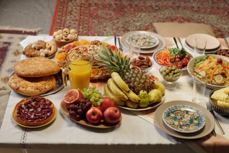 High angle view no people shot of Uraza Bayram festive table set with various dishes in living room, copy space