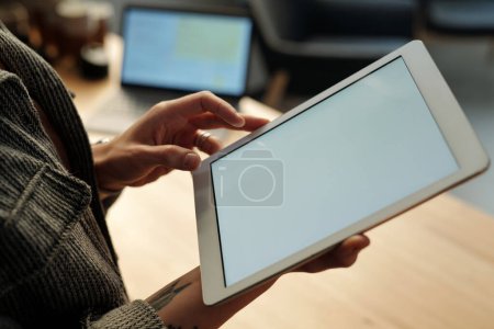 Foto de Tableta con pantalla en blanco en manos de una joven solista moderna o una mujer autónoma que busca información en Internet - Imagen libre de derechos