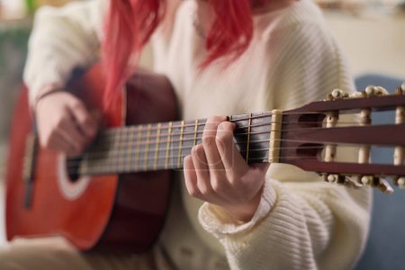 Téléchargez les photos : Close-up of young talented female musician playing acoustic guitar in front of camera while performing and recording her new song - en image libre de droit