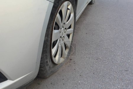 Photo for Car with punctured flat tire parked on roadside - Royalty Free Image