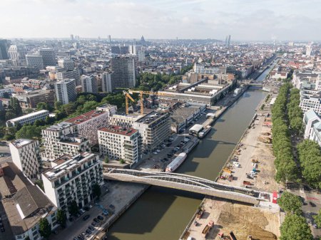 Téléchargez les photos : Bruxelles, Belgique - 12 mai 2022 : Paysage urbain de la ville de Bruxelles. Le canal de la Senne traversant Bruxelles et un pont pour cyclistes et piétons en construction. En arrière-plan le o - en image libre de droit