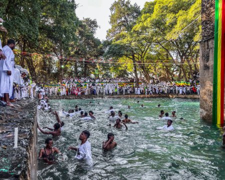 Photo for Gondar, Ethiopia, 19 January 2023; Crowd around the Fasiladas bath celebrating Timkat, an Ethiopian Orthodox celebration in Gondar, Ethiopia, worshippers jump into the water - Royalty Free Image