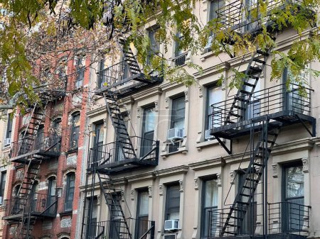 Foto de Viejos edificios coloridos con escalera de incendios y árboles en Nueva York Manhattan, Upper East Side, edificios casa delantera - Imagen libre de derechos