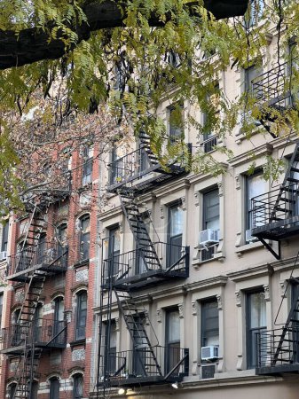 Foto de Viejos edificios coloridos con escalera de incendios y árboles en Nueva York Manhattan, Upper East Side, edificios casa delantera - Imagen libre de derechos