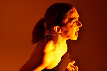 Photo for Head and shoulders close up portrait of pretty girl with expressive facial expressions, with  colourful neon gel lighting, isolated on studio background. - Royalty Free Image