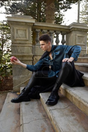 Photo for Portrait of handsome brunette male model wearing fantasy medieval prince costume, romantic silk shirt. Wandering around historical castle location background with stone staircase. - Royalty Free Image