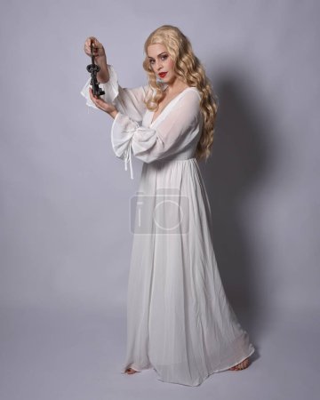 Photo for Full length portrait of blonde woman  wearing  white historical bridal gown fantasy costume dress. Standing pose, facing backwards walking away from camera, isolated on studio background. - Royalty Free Image