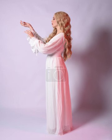 Photo for Full length portrait  of blonde woman  wearing white historical bridal gown fantasy costume dress.   Standing pose, facing backwards walking away from the camera. isolated on studio background. - Royalty Free Image