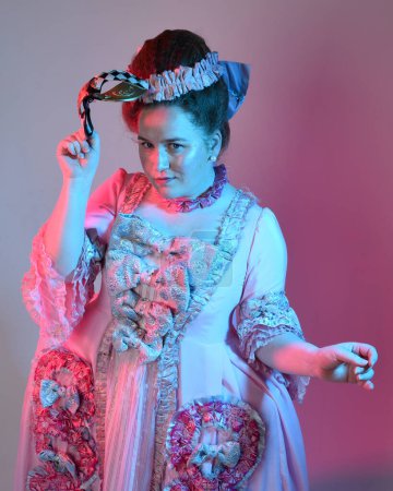  portrait of female model wearing an opulent pink gown,  costume of a historical French baroque nobility, style of Marie Antoinette. Isolated on  studio background cinematic  colourful lighting